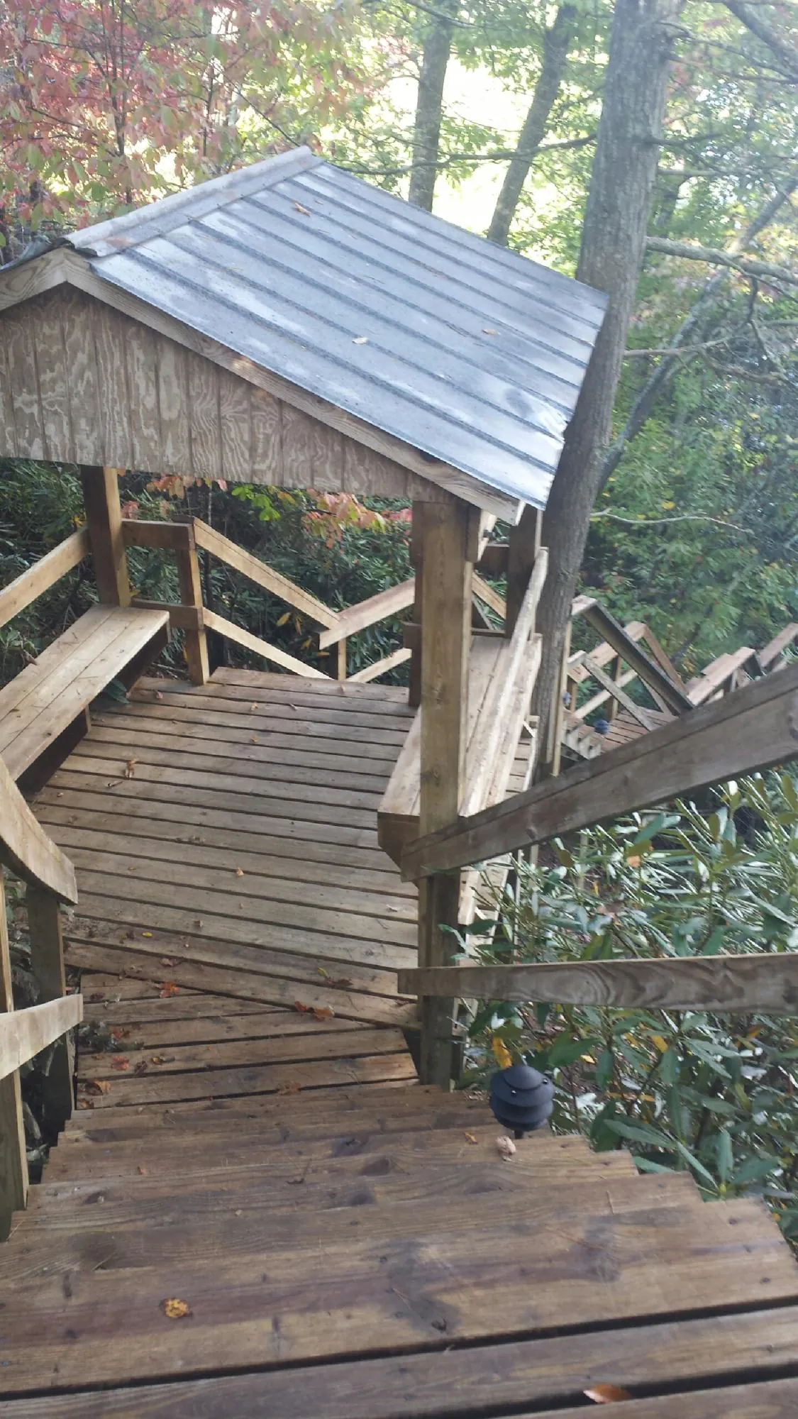 Metal roofed shelter over wooden steps on a wooded walkway — Skylight Repair & Installation work by our crew in Coatesville