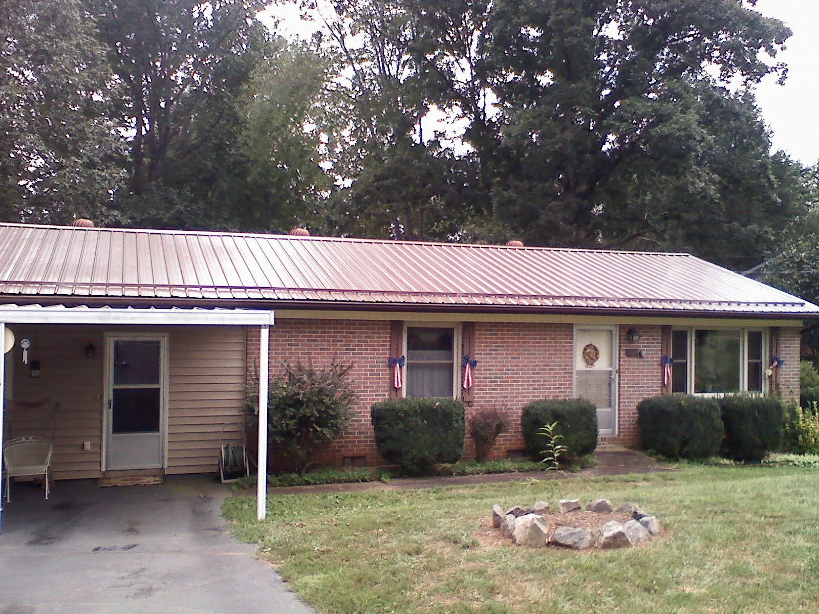 Bronze metal roof and carport on a brick ranch home — Roof Repair work by our crew in Coatesville